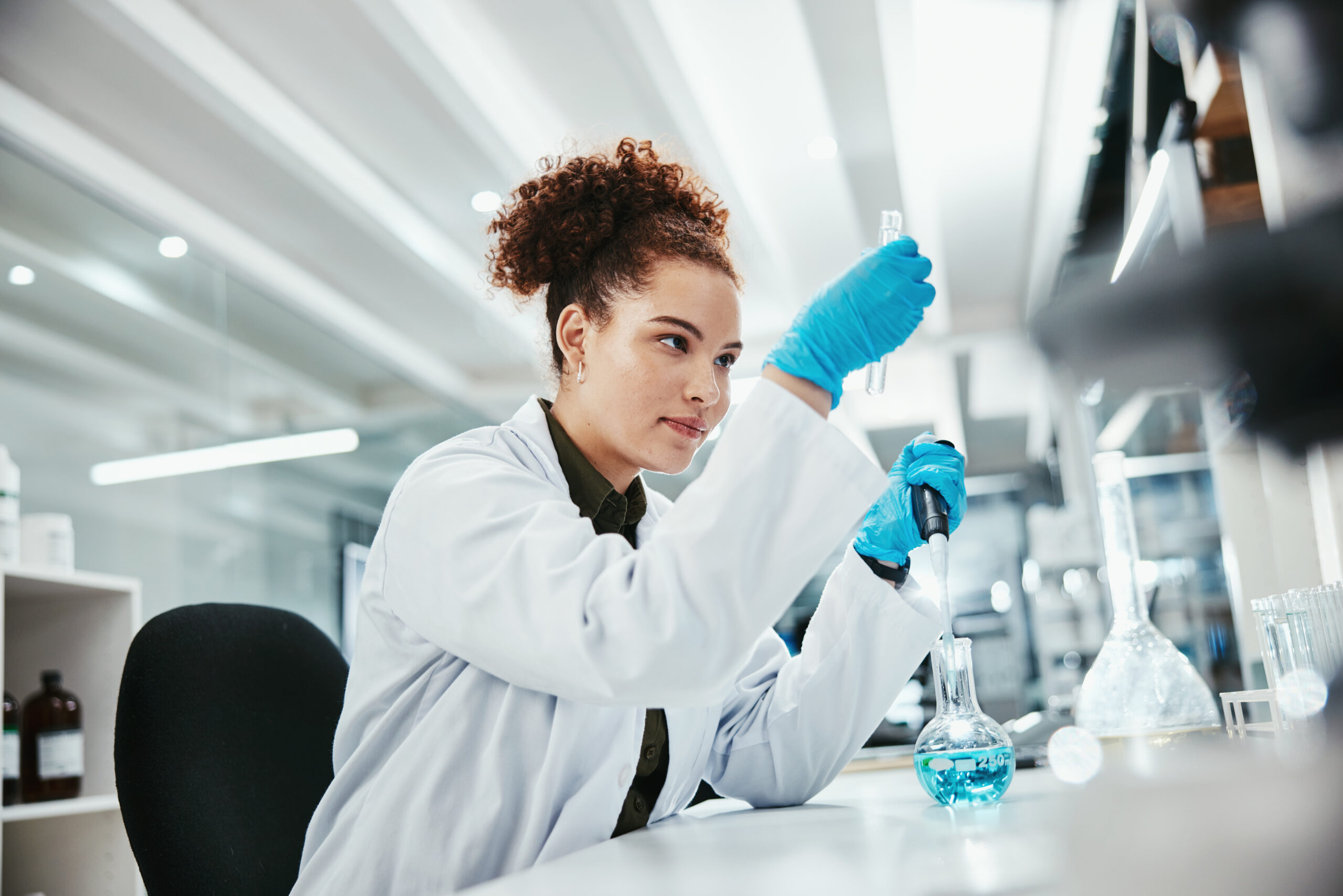 Thumbnail image of a woman examining liquids in glass beakers.