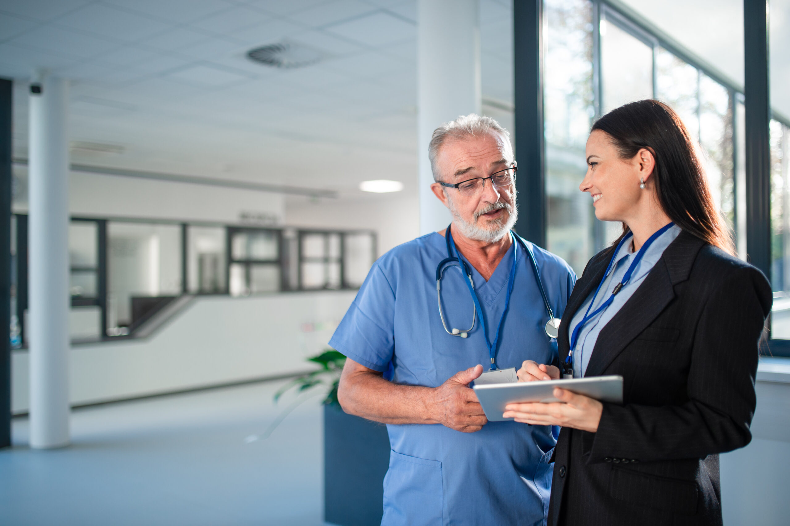 Thumbnail image of young business woman and an elderly physician in a hospital.